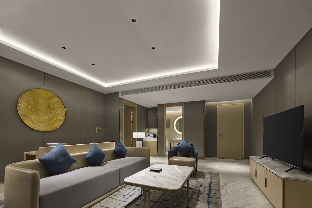 A modern living room with a sofa, coffee table, and a TV.
