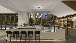 Uma área de bar moderna com bancada de mármore, banquetas, uma máquina de café e uma vitrine de vidro com garrafas.