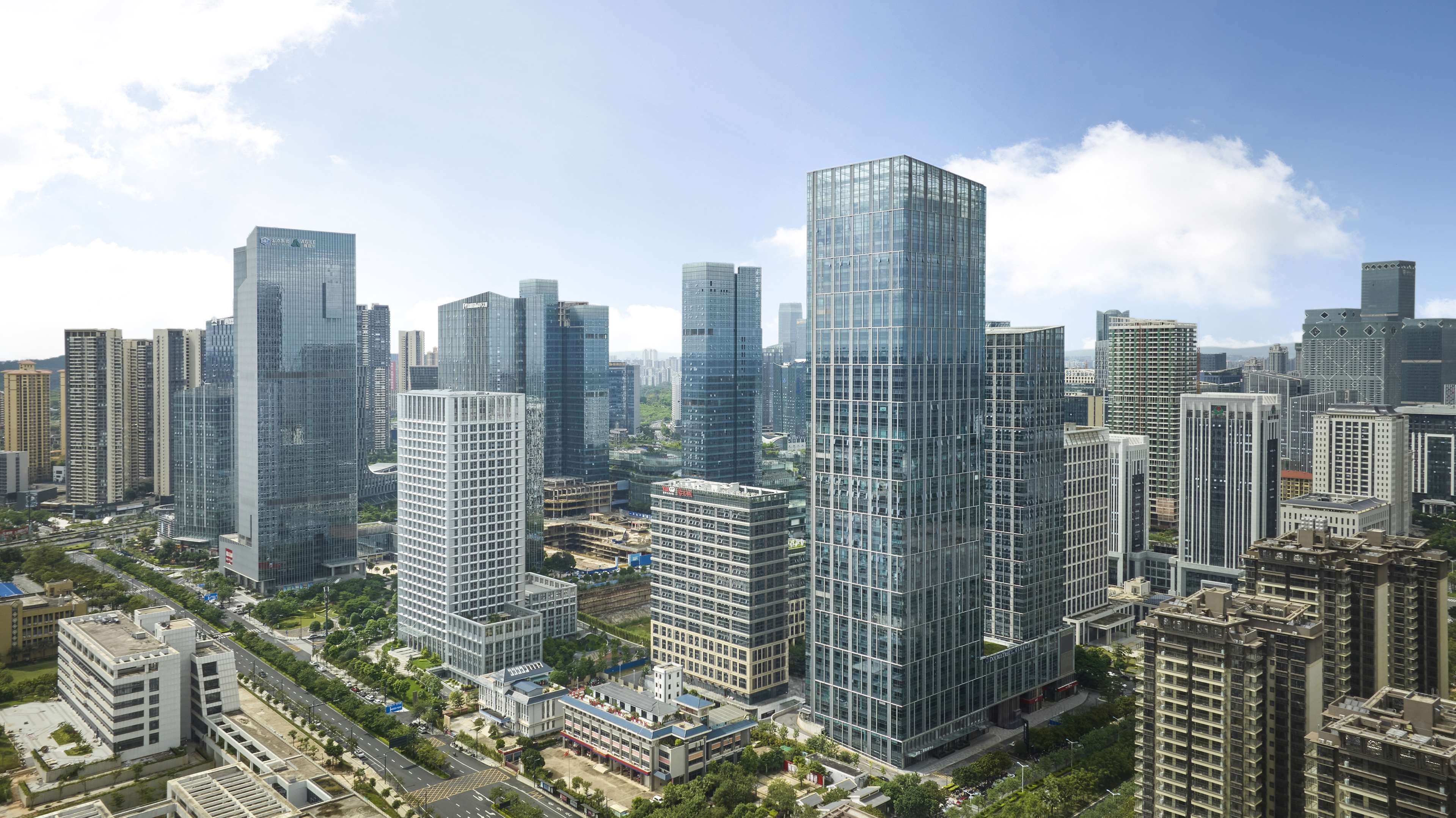 A high-rise urban area with modern skyscrapers, roads, and greenery.