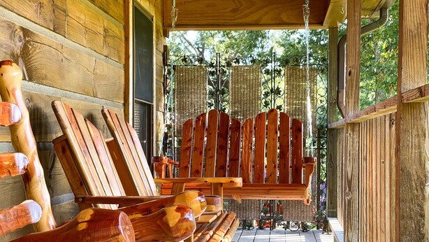 A wooden porch with a bench and a welcome sign. - Valentine Drive Cabin 1 (Lookout Mountain)