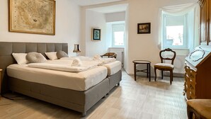 A bedroom with a large bed, a chair, a dresser, and a window. - Apartment Fuchsbau (Senftenberg)