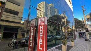A modern hotel with reflective glass facade, a visible entrance, and a sign indicating it is a Samba hotel.