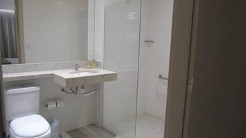 A bathroom with a toilet, sink, and shower.