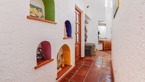 A hallway with white walls, green and purple arches, and a tiled floor. - Amazing home for 10 people. "La Casa del Laurel" (Tepoztlán)