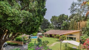 A residential property with a swimming pool, a covered patio, and lush greenery. - Amazing home for 10 people. "La Casa del Laurel" (Tepoztlán)