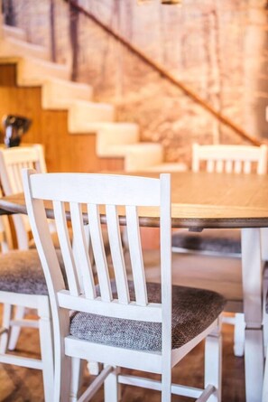 A dining area with white chairs and a wooden table.