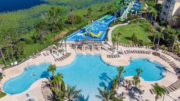 Un complexe hôtelier doté de plusieurs piscines, d’un parc aquatique et d’un bâtiment avec des balcons.