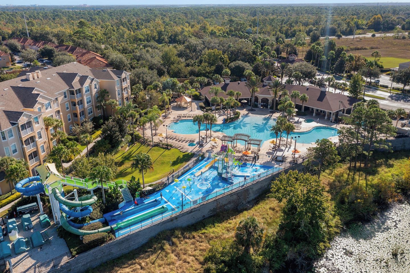 A resort with multiple swimming pools, a water park, and a residential area with apartment buildings.