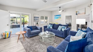 Ein modernes Wohnzimmer mit zwei Sofas, einem Glastisch und einem Kamin.