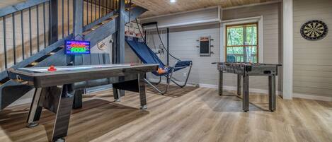 Una habitación con mesa de fútbol, dardos y billar.