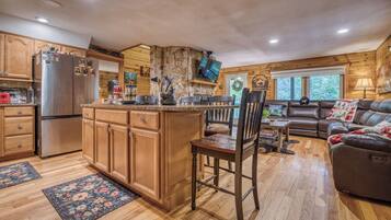 A cabin interior with a kitchen, dining area, and living room.