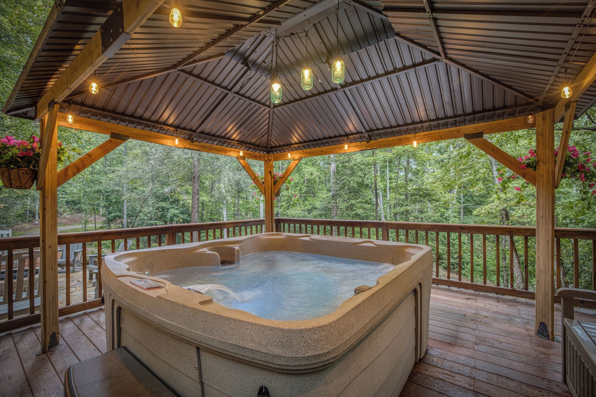 Un jacuzzi bajo un porche de madera con vista a un bosque.