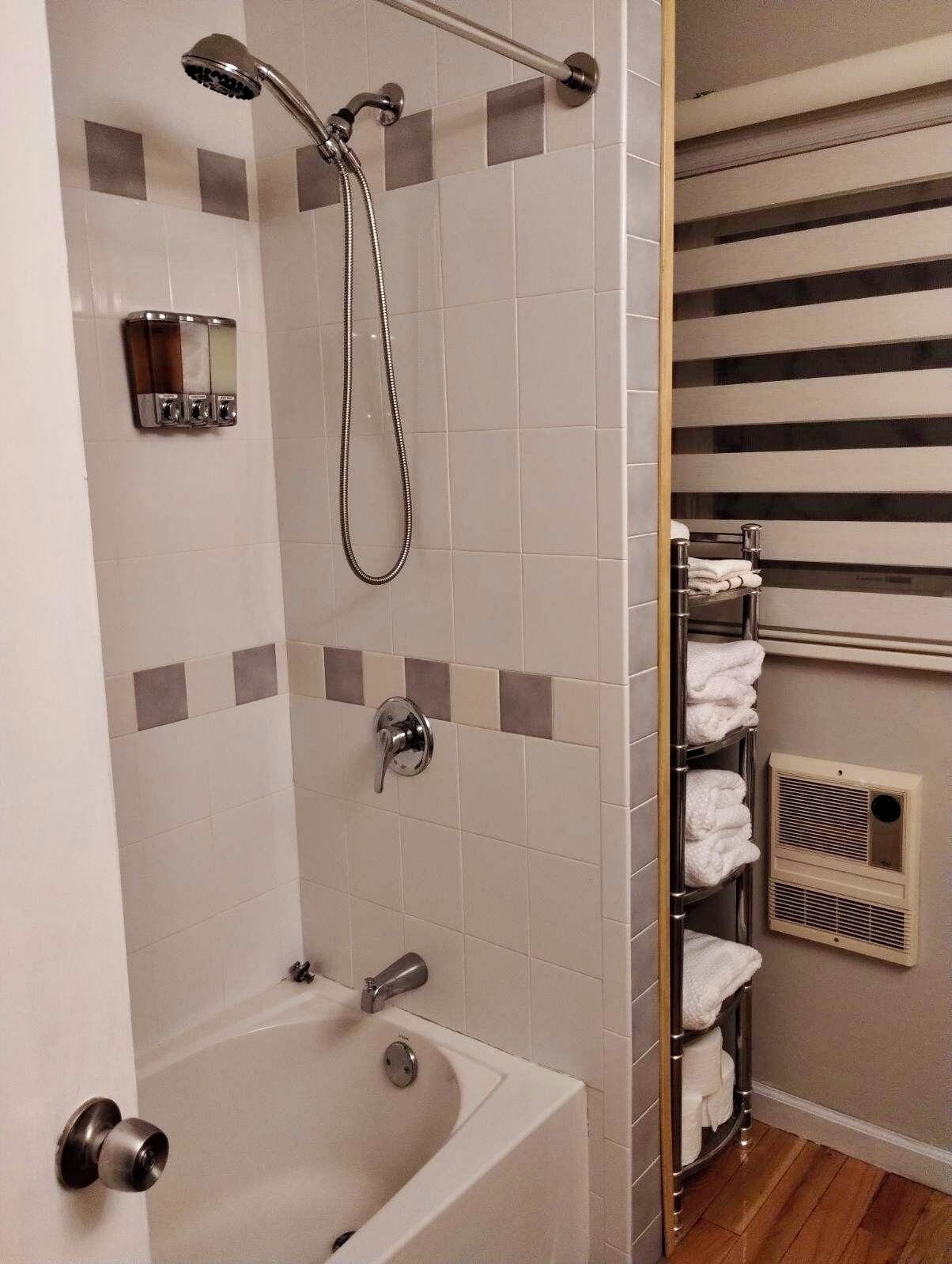 Un baño moderno con bañera, ducha y toallero.