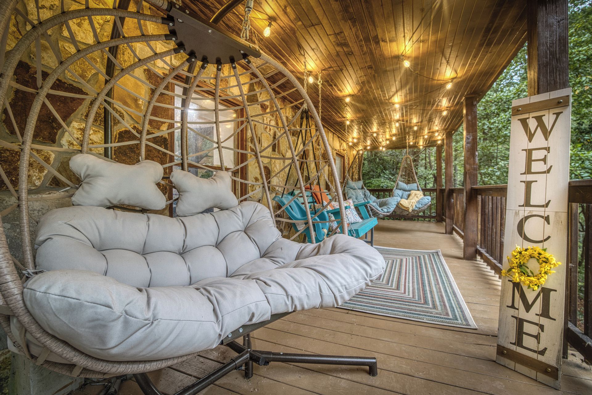 Eine Holzterrasse mit Schaukelstuhl und einem 'WELCOME'-Schild.