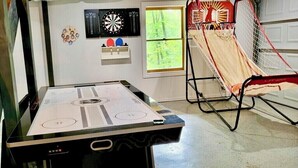 Ein Raum mit Tischfußball, Dart und Basketballkorb.