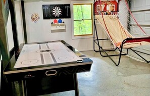 A room with a foosball table, dartboard, and basketball hoop. - Bearfoot Bliss-Bear Hunt • Arcade • Hot Tub- Fire Pit- Adventure Cabin-Sleeps 12 (Blairsville)