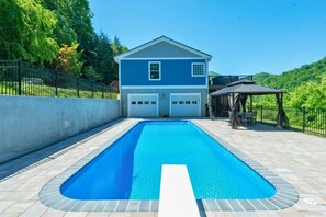 Una casa con piscina, garaje y un patio cubierto.