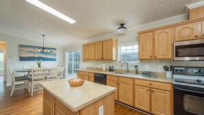 A modern kitchen with wooden cabinets, a central island, a dishwasher, and a stainless steel oven. - Heated Private Saltwater Pool; Hot Tub; 15 min AVL; 10 min Blue Ridge Parkway (Candler)