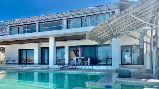 A modern house with a swimming pool, a covered patio, and a large window overlooking the pool. - Casa A LA Orilla DEL MAR CON Piscina (Telchac Puerto)