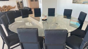 A modern dining area with a glass table surrounded by black chairs. - Casa A LA Orilla DEL MAR CON Piscina (Telchac Puerto)