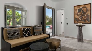 Un soggiorno moderno con un divano, due tavolini e un grande quadro astratto appeso al muro.