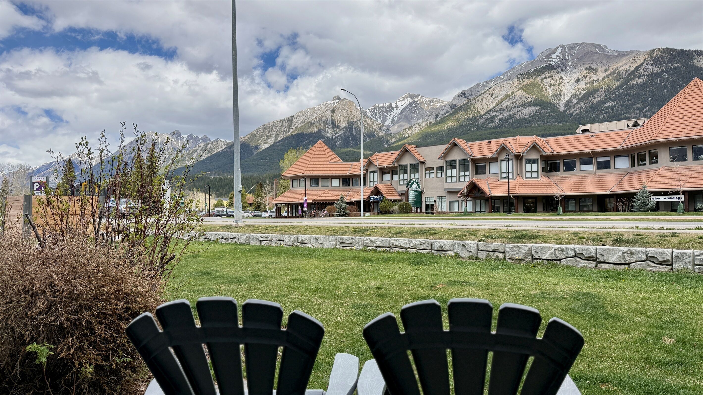 Ett hotell med flera byggnader, en parkeringsplats och berg i bakgrunden.