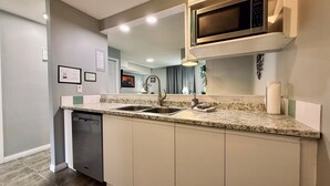 A modern kitchen with granite countertops, stainless steel appliances, and a built-in microwave. - Cozy Rocky Mountain Chalet | Pet Friendly (Canmore)