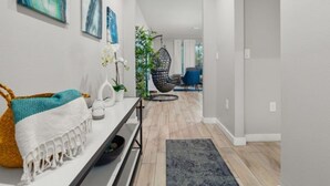 A modern hallway with a bench, artwork, a hanging chair, and a plant. - Disney Getaway w/ Splash Pool + Kids’ Theme Rooms (Kissimmee)