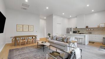 Enjoy a stylish living space with a dining area, sofa, and kitchen, perfect for relaxing and socializing.