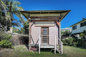 A small, single-story building with a wooden door and a metal roof. - High On Jeffery in the Heart of Agnes Water (Agnes Water)