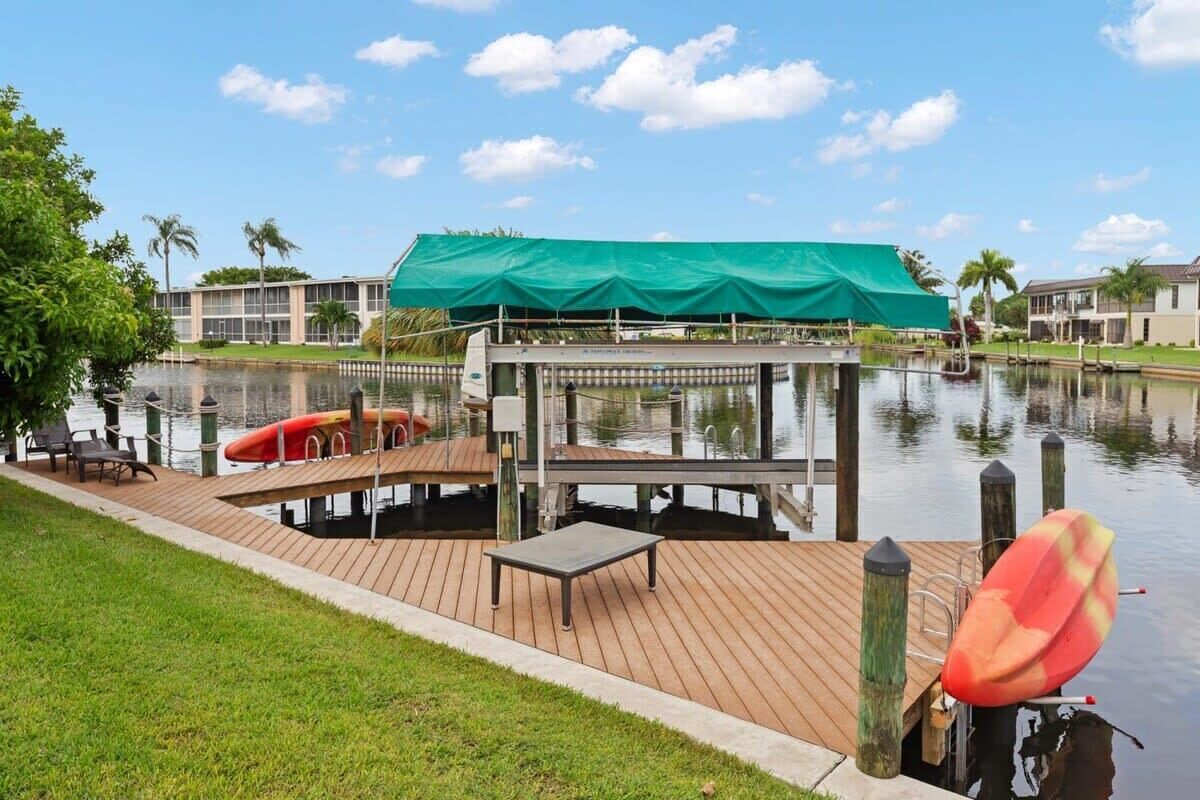 A dock with a covered seating area, a small table, and a kayak.