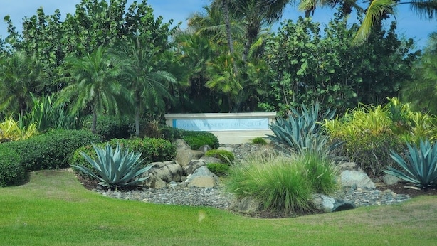 Un jardin bien entretenu, agrémenté d’un panneau indiquant le Grand Reserve Golf Club.