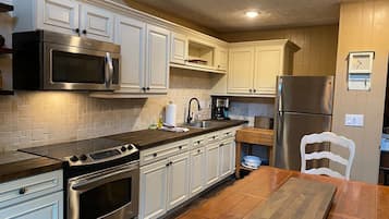 Microondas, cafetera y tetera, utensilios de cocina y comedor