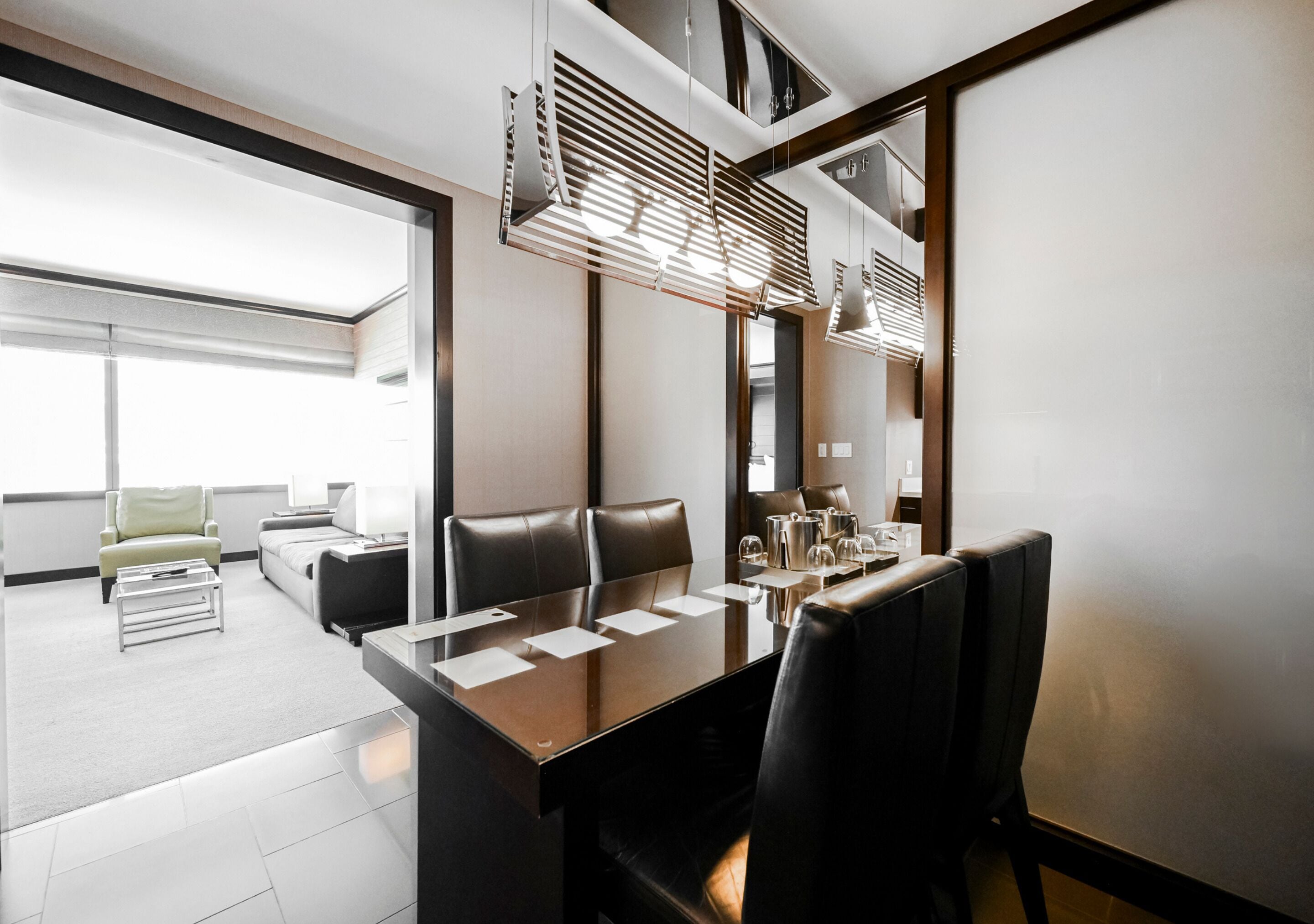 A modern conference room with a large table, leather chairs, and a large window providing natural light.