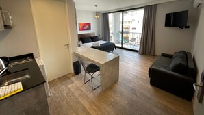 Eine moderne Wohnung mit Küche, Essbereich, Wohnzimmer und einem Balkon mit Blick.