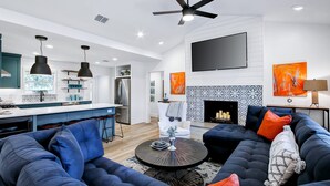 Una sala moderna con un amplio sofá modular, una mesa de centro y una chimenea.