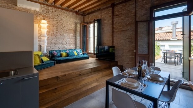 A modern kitchen with a wooden countertop and a built-in oven. - VELLUTO Luxury open space mezzanine and terrace self check in (Venezia)