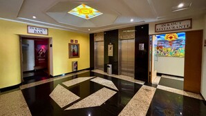 A hotel lobby with a checkered floor, an elevator, a 'Bar' sign, and a 'Restaurant' sign. -  Hot Plaza Camarones | Love Hotel | Solo Adultos (Mexico City)