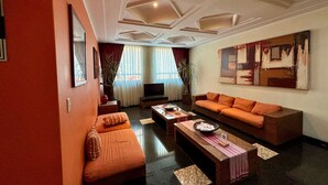A modern living room with a sofa, coffee table, and TV. -  Hot Plaza Camarones | Love Hotel | Solo Adultos (Mexico City)