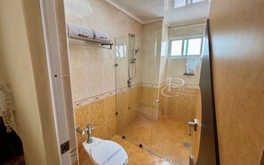 Habitación doble estándar | Baño | Regadera, secadora de cabello, pantuflas, toallas 