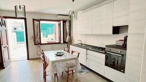 Una cocina compacta con una mesa de comedor, sillas, estufa y armarios.