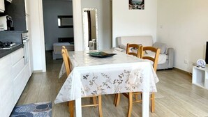 Un espacio habitable compacto con comedor, kitchenette y sofá.