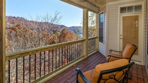 A covered porch with a view of autumn foliage and hills. - Luxury in Rumbling Bald Resort ~ WiFi ~ Community Beach, Pool, Golf and more (Lake Lure)