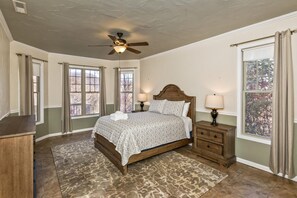 A bedroom with a bed, nightstands, a ceiling fan, and large windows. - Luxury in Rumbling Bald Resort ~ WiFi ~ Community Beach, Pool, Golf and more (Lake Lure)