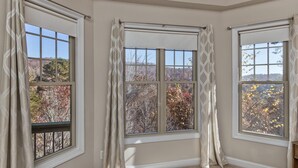 A room with three windows, each with a view of autumn foliage. - Luxury in Rumbling Bald Resort ~ WiFi ~ Community Beach, Pool, Golf and more (Lake Lure)