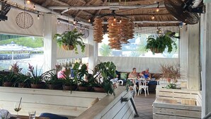 Un ristorante con panche di legno, piante pensili e un segnale di uscita.