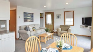 A living room with a sofa, armchairs, a coffee table, and a TV. - Views of Bay Access to Private Beach! (Truro)
