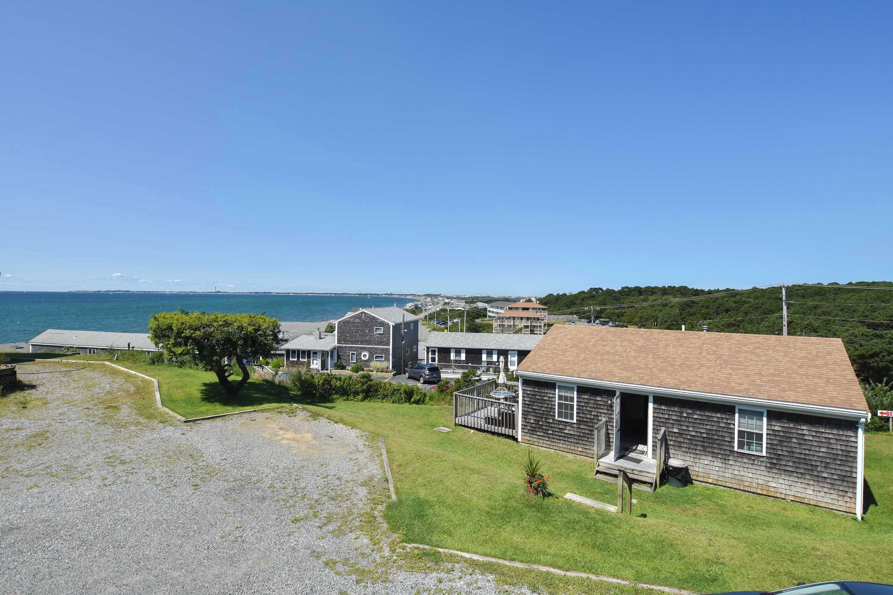 Un quartier résidentiel situé sur la côte, avec des maisons, une pelouse et une vue sur la mer.