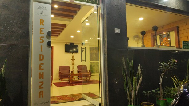 L’entrée de l’hôtel Sri Dhevi, avec un comptoir d’accueil, un espace salon et des plantes en pot.
