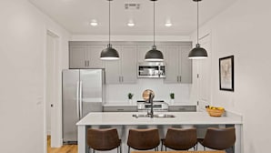 A modern kitchen with a central island, stainless steel appliances, and pendant lighting. - Beach Lagoon Escape #78 by RedAwning (St. George)